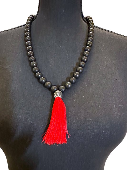 Black beaded necklace with red tassel