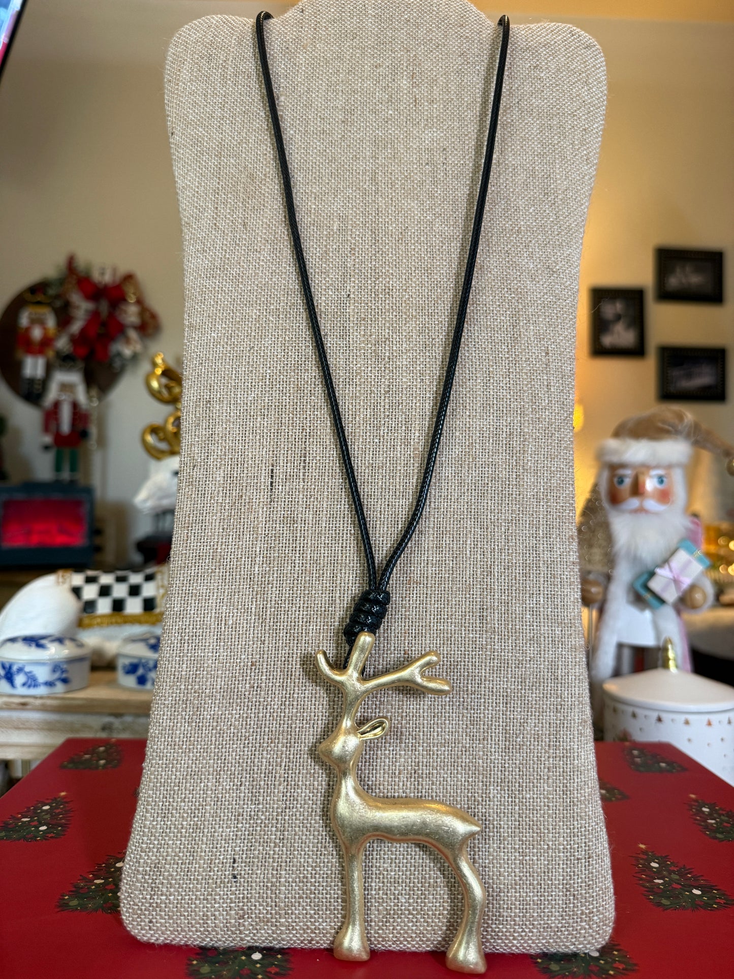 Large matt gold reindeer pendant on a black cord necklace