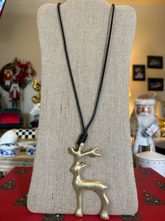 Large matt gold reindeer pendant on a black cord necklace