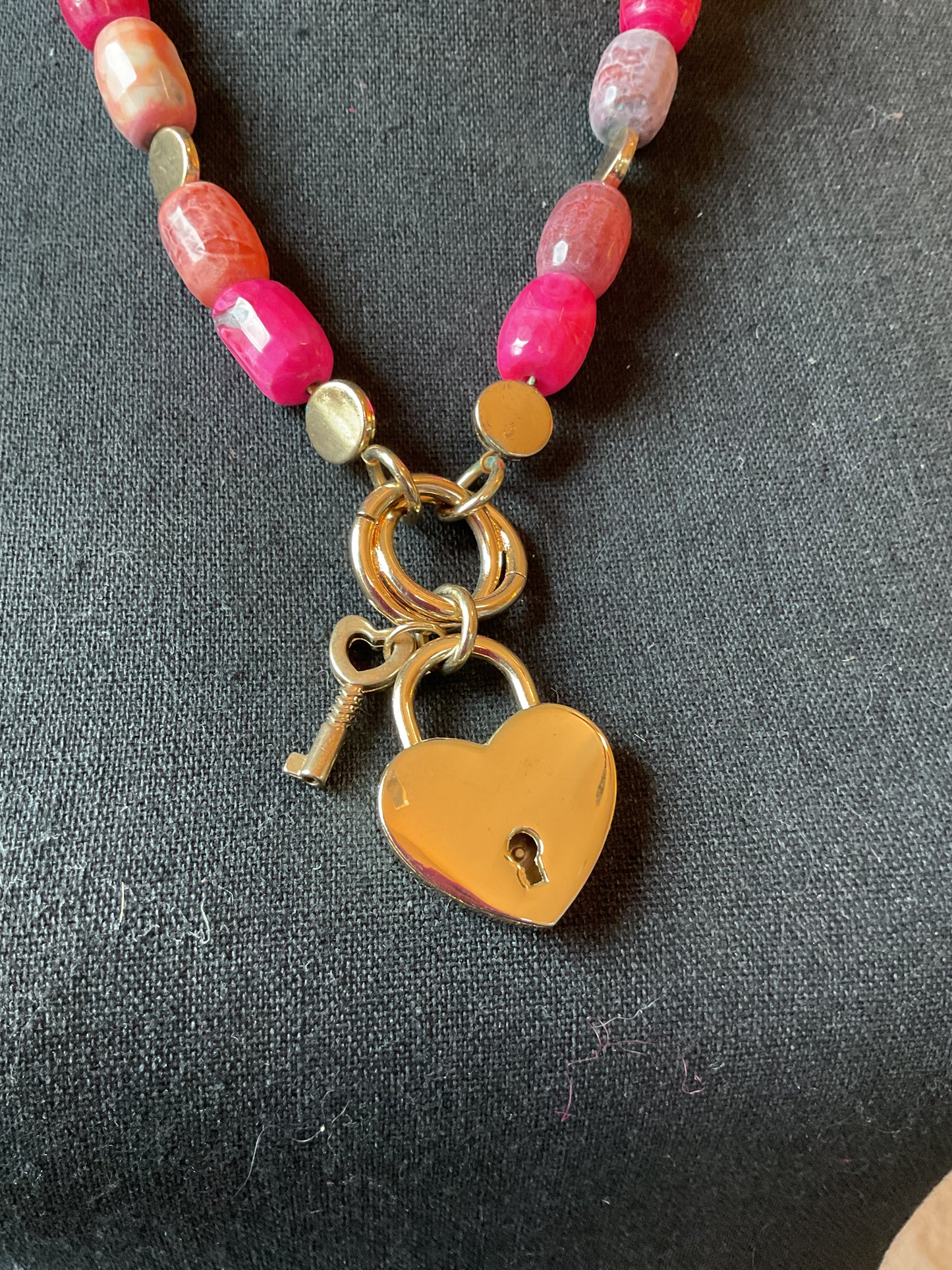 Multi color beaded necklace with gold tone heart locket pendant
