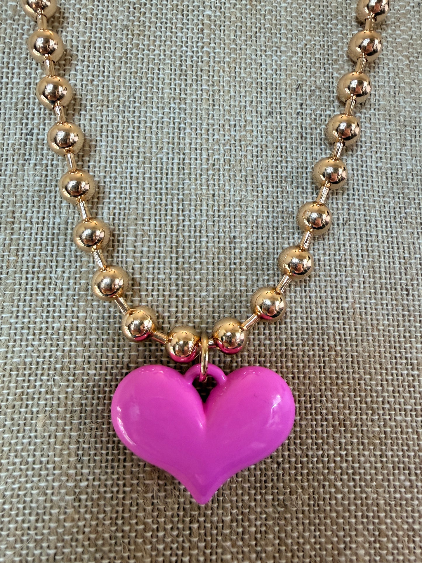 Gold tone ball chain necklace with bright pink puffy heart pendant