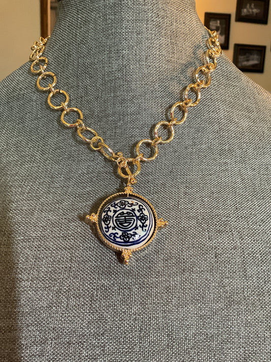 Gold chain with a blue and white pendant