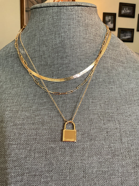 Multi layer gold chain necklace with a lock pendant